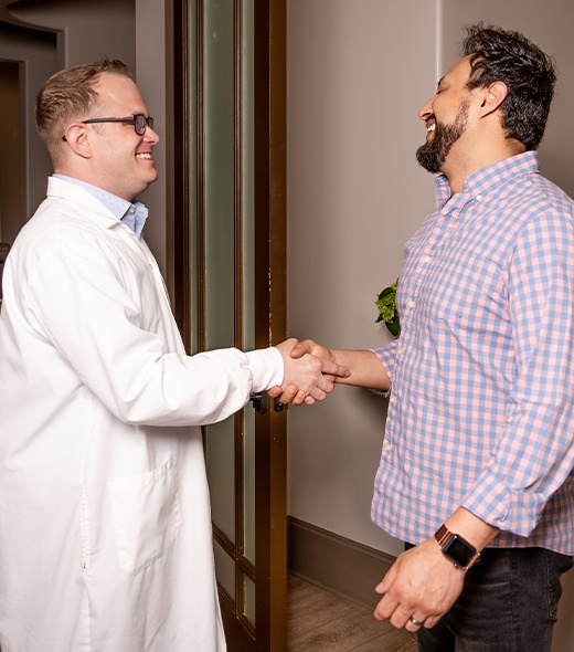 Doctor Shivley shaking hands with dental patient