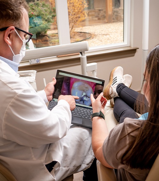 Dentist and patient looking at smile images on computer screen