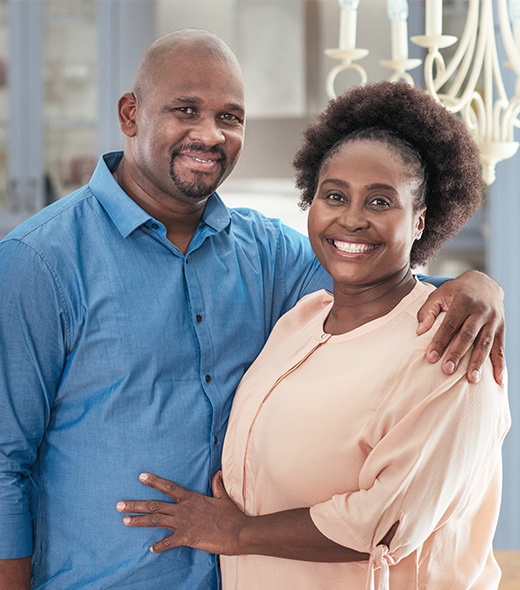 Man and woman with dental crowns sharing beautiful smiles