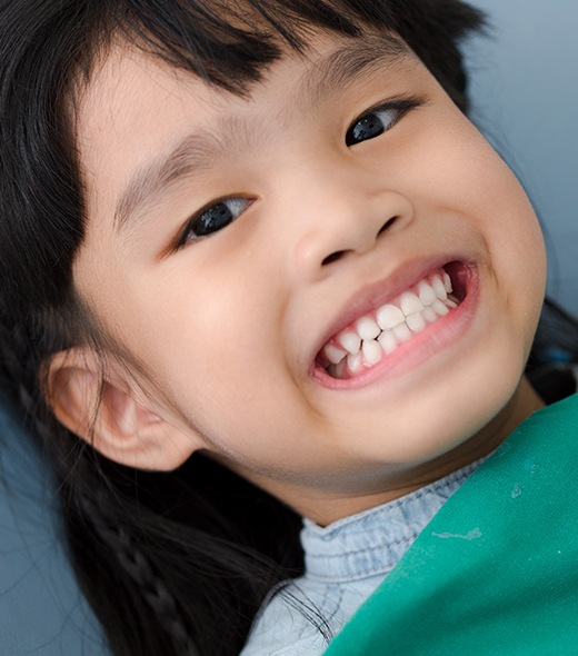 Child with healthy smile after fluoride treatment