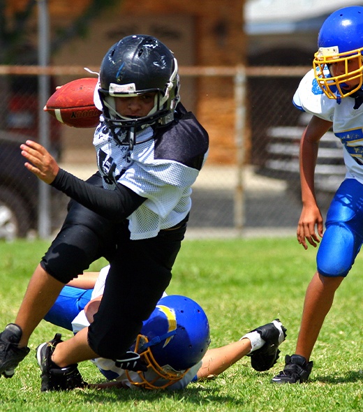 Teen playing football with athletic mouthguard