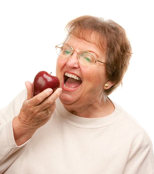 Woman with dentures biting an apple