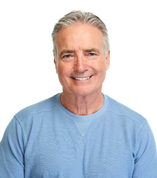 Man in blue shirt smiling with white background