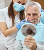 Dental implant candidate in Lubbock admiring his new smile