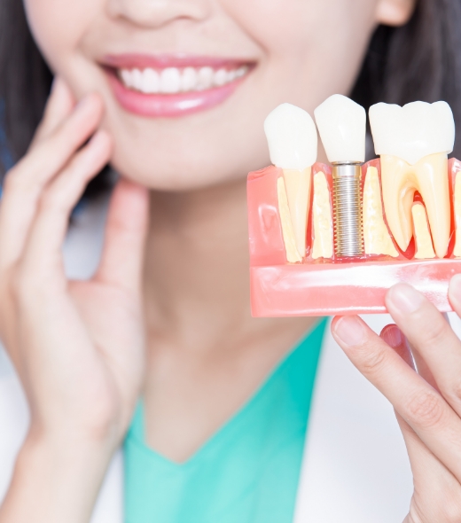 Woman eating a green apple after dental implant tooth replacement