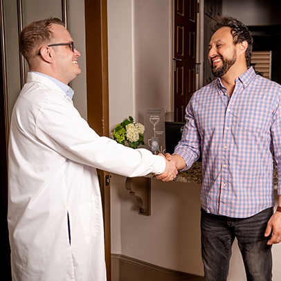 Doctor Shivley shaking hands with dental patient