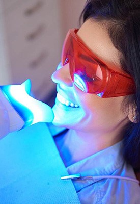 Woman undergoing in-office teeth whitening treatment