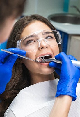 Woman looking at dentist performing her root canal