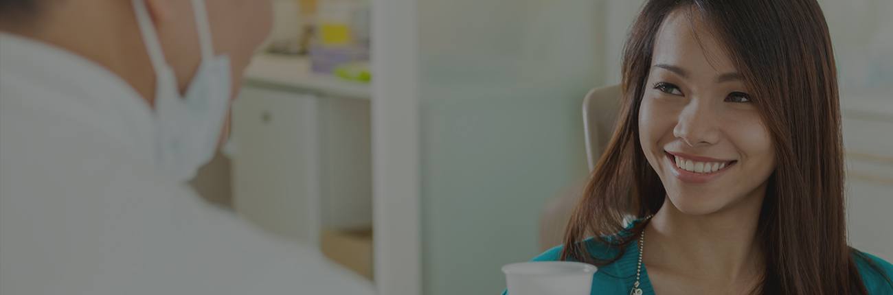 Woman smiling at dentist during preventive dentistry visit