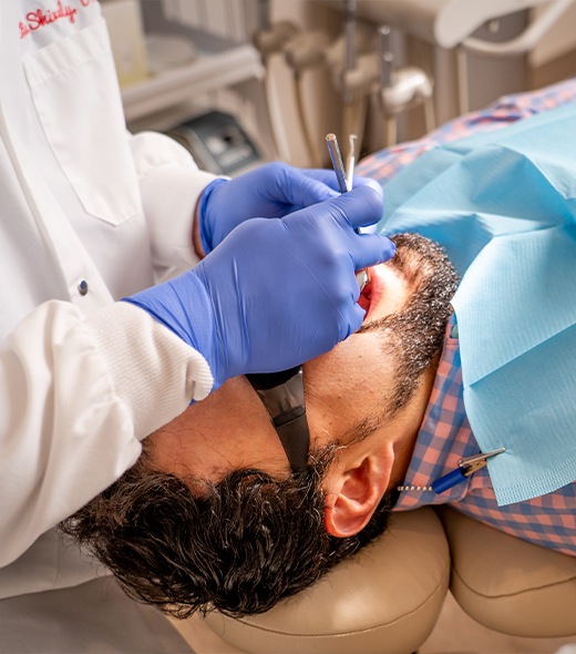 Man receiving dental checkup and teeth cleaning treatment