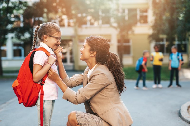 Mom and daughter smiling on first day of school