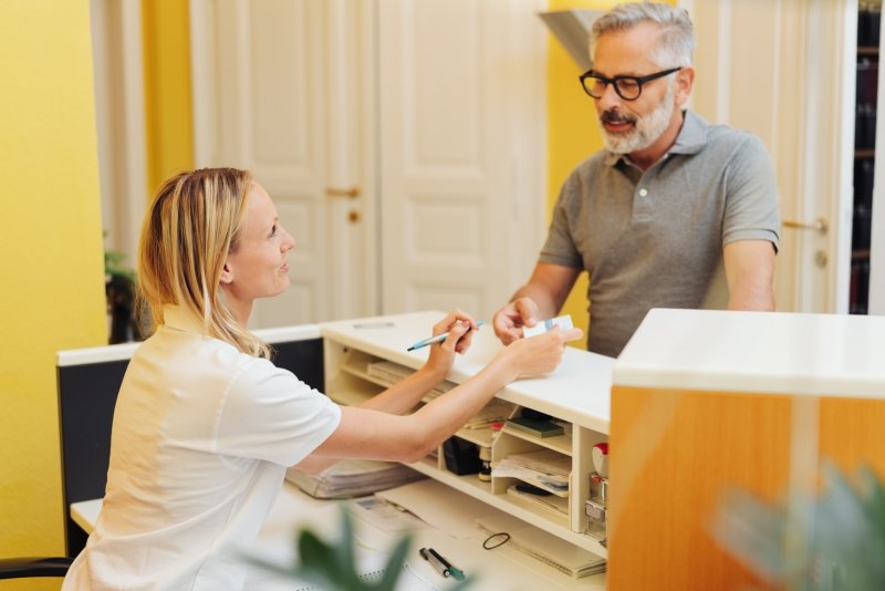 Man paying receptionist