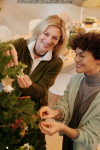 Two women decorating a tree