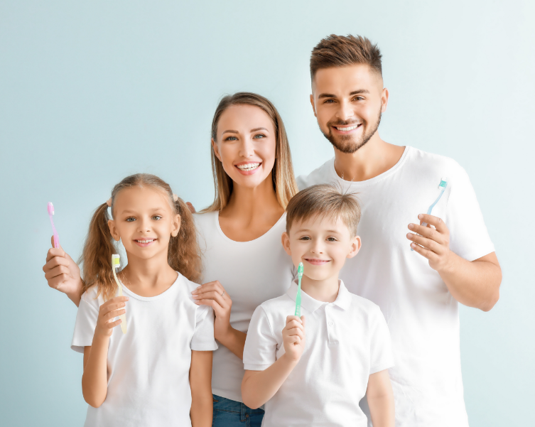 Family smiling and holding toothbrushes